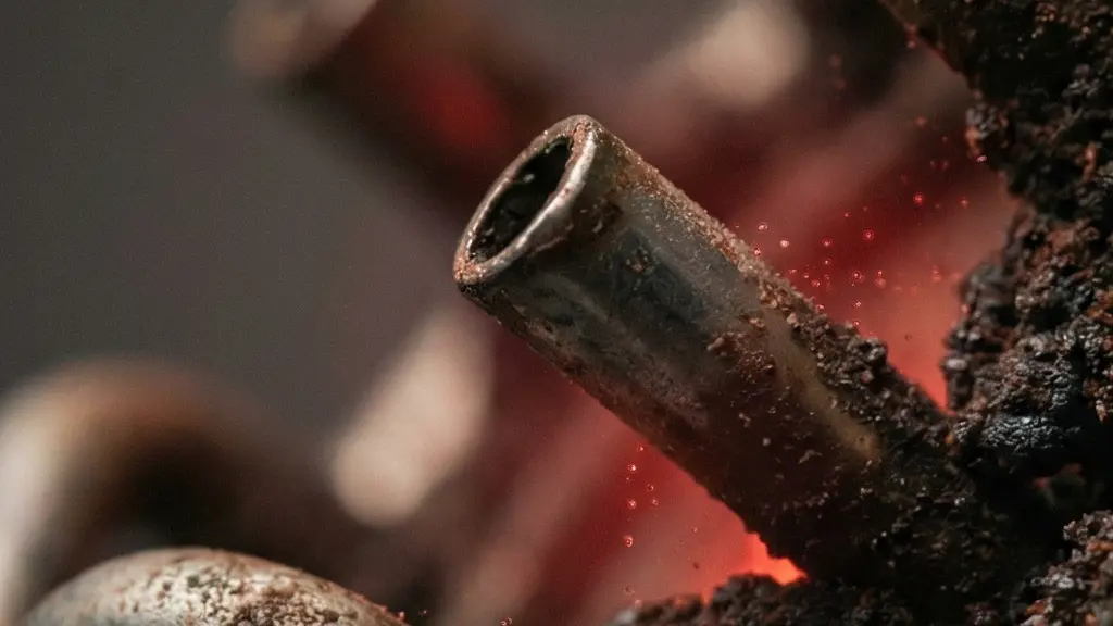 Gros plan de petits tubes métalliques rouillés et rétrécis avec une lumière rouge diffuse, métaphore d'une microcirculation altérée et d'un manque d'oxygénation des tissus.